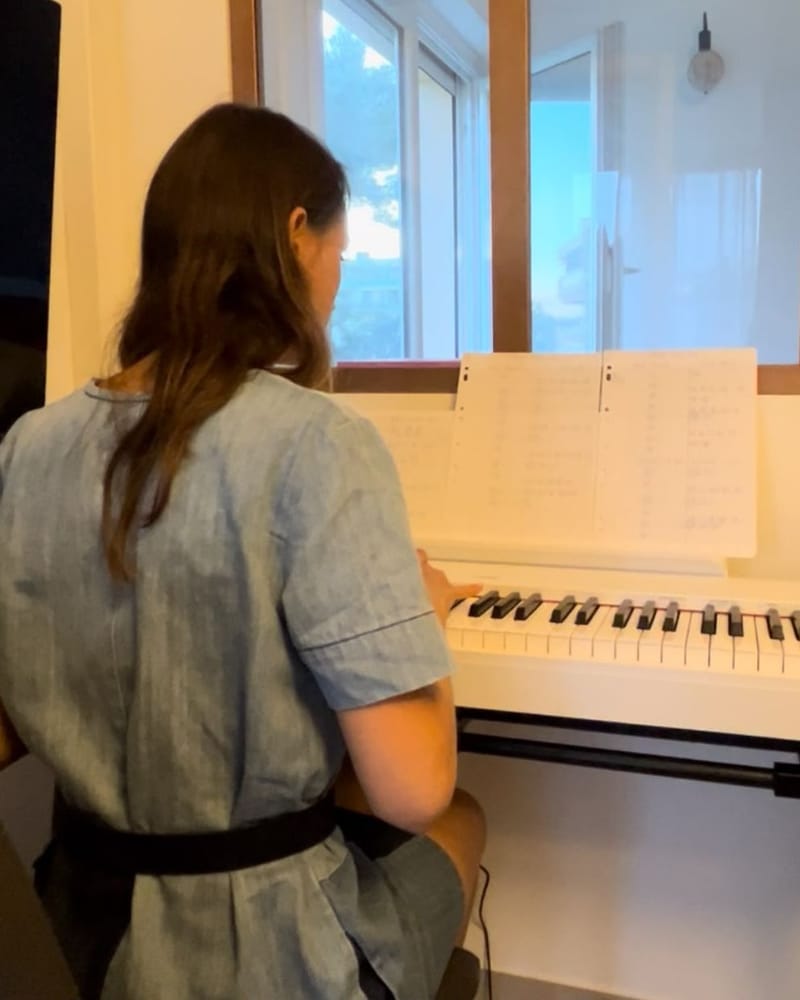 Une élève de Maéna joue au clavier, ses partitions devant elle